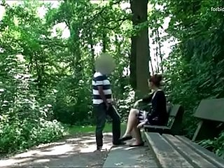 El hombre acecha a una mujer en un parque